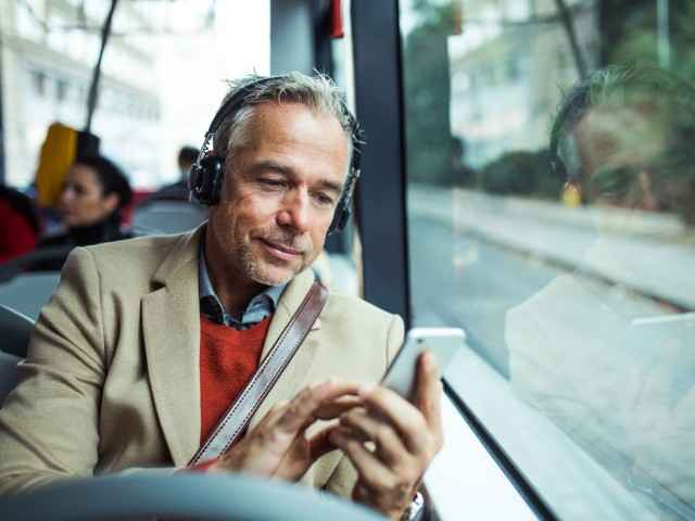 Ein Mann im Bus benutzt die Tinnitus-App.